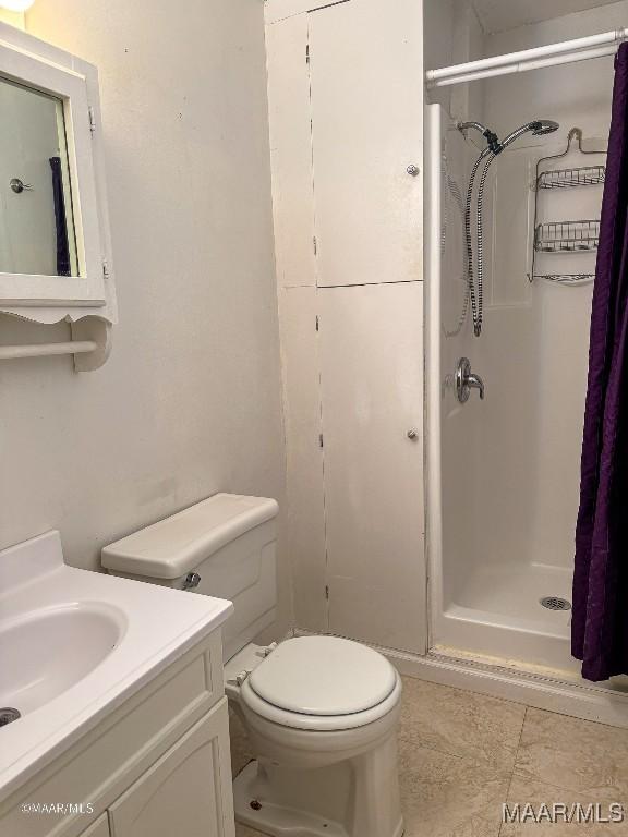 bathroom featuring vanity, toilet, and walk in shower