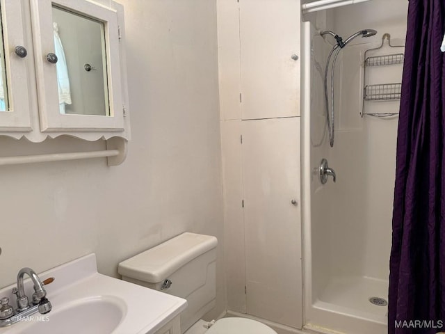 bathroom featuring vanity, toilet, and walk in shower