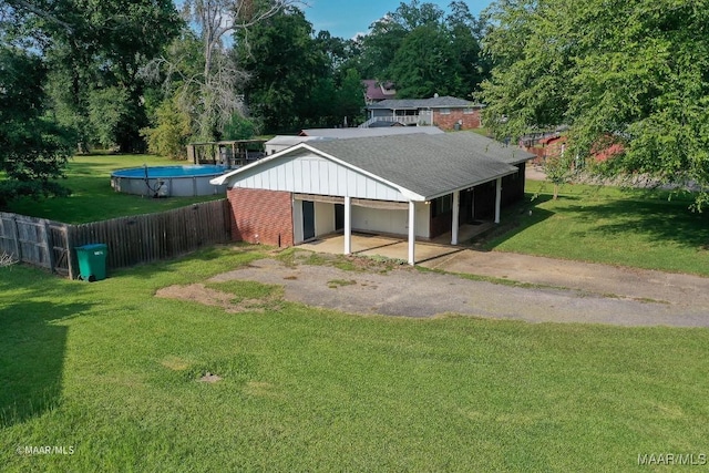 view of front of property with a front yard and a fenced in pool