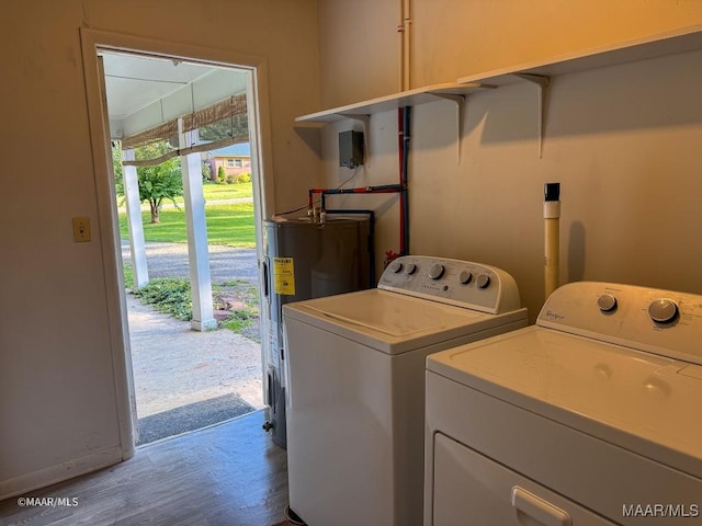 laundry room featuring hardwood / wood-style flooring, washing machine and dryer, and electric water heater