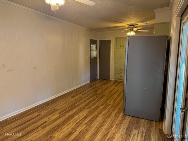 empty room with crown molding, a textured ceiling, and light wood-type flooring