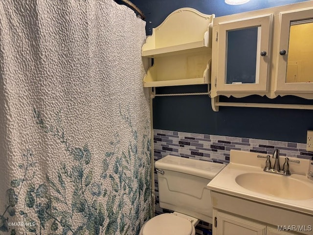 bathroom with decorative backsplash, vanity, and toilet