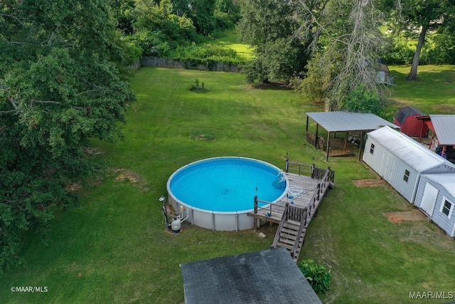 view of pool with a deck, an outdoor structure, and a yard