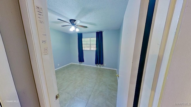 unfurnished room featuring a textured ceiling and ceiling fan