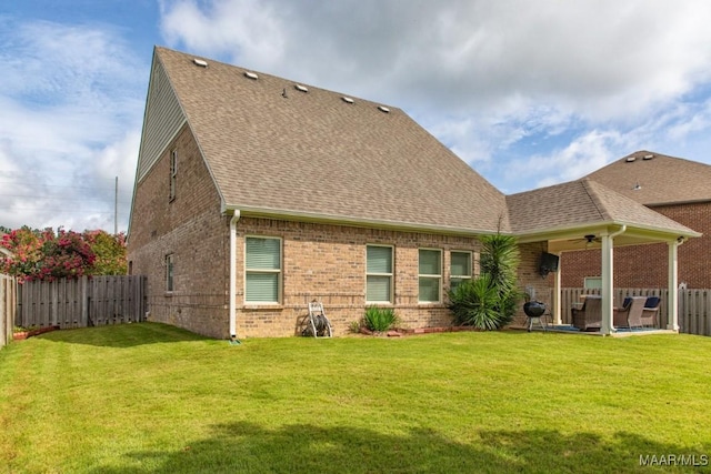 back of house with ceiling fan, a yard, and a patio area