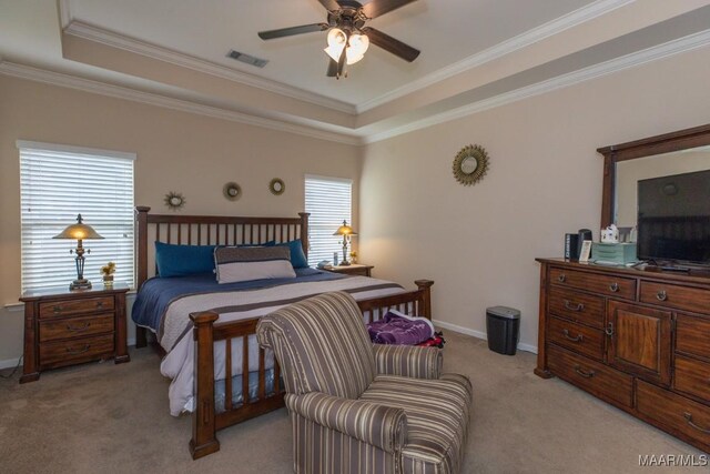 carpeted bedroom featuring ceiling fan, ornamental molding, and a tray ceiling