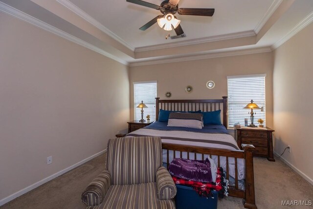 bedroom with ceiling fan, ornamental molding, a tray ceiling, and carpet floors