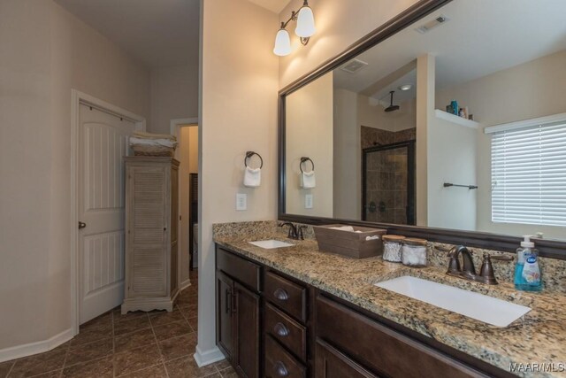 bathroom featuring vanity, a shower with shower door, and tile patterned floors