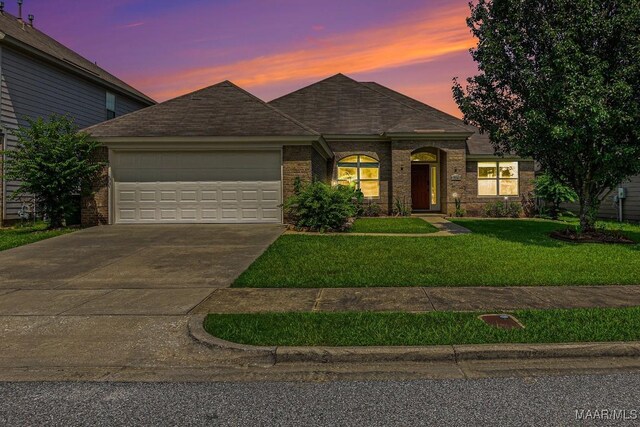 view of front of property with a yard and a garage