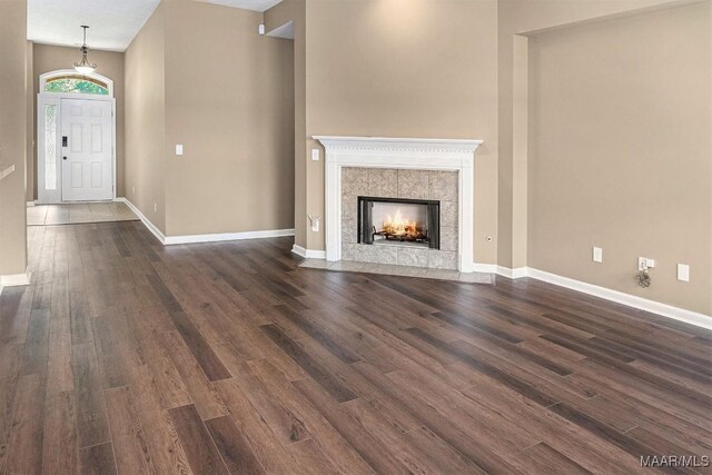 unfurnished living room with a fireplace, a textured ceiling, vaulted ceiling, and dark hardwood / wood-style floors