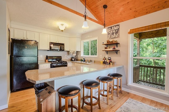 kitchen featuring hanging light fixtures, white cabinetry, kitchen peninsula, and black appliances