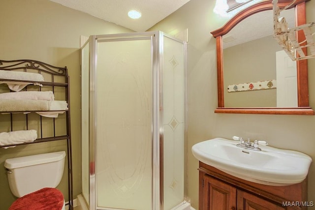 bathroom featuring a shower with door, vanity, and toilet