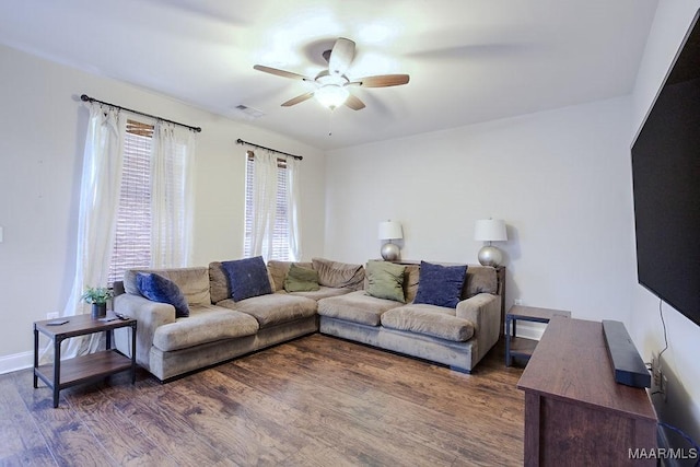 living room with dark wood-type flooring and ceiling fan