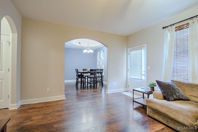 living room with dark hardwood / wood-style floors and a notable chandelier