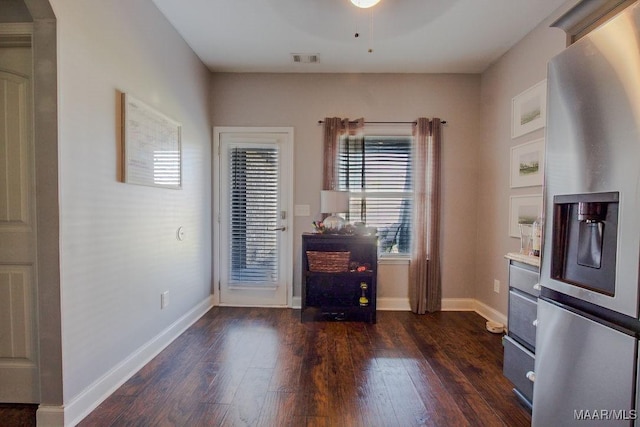 interior space with dark wood-type flooring and stainless steel refrigerator with ice dispenser