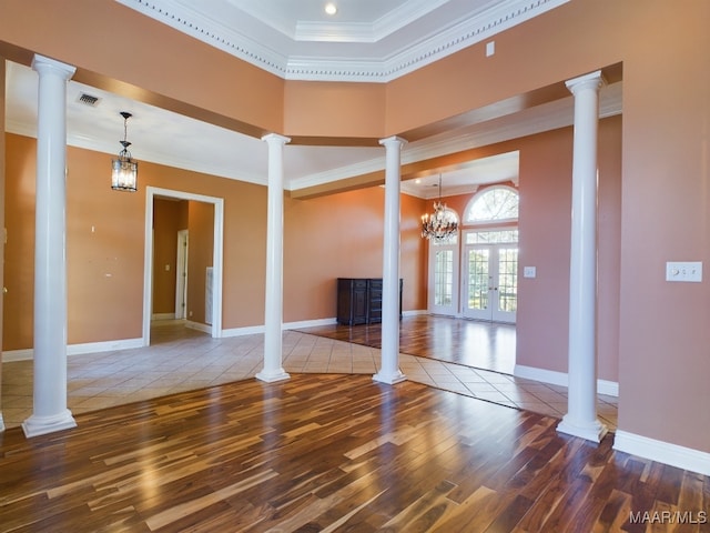 unfurnished living room with decorative columns, tile patterned flooring, french doors, crown molding, and a chandelier