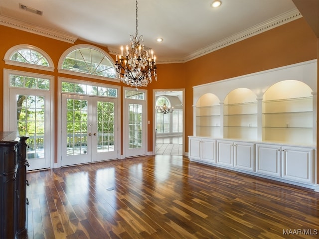 interior space featuring crown molding, french doors, hardwood / wood-style floors, and an inviting chandelier