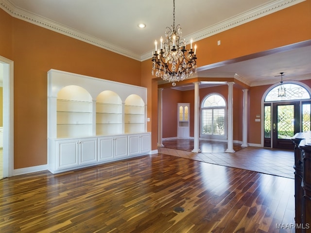 foyer entrance with baseboards, decorative columns, wood finished floors, and a notable chandelier
