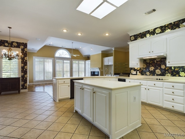 kitchen featuring black appliances, pendant lighting, kitchen peninsula, a kitchen island, and lofted ceiling