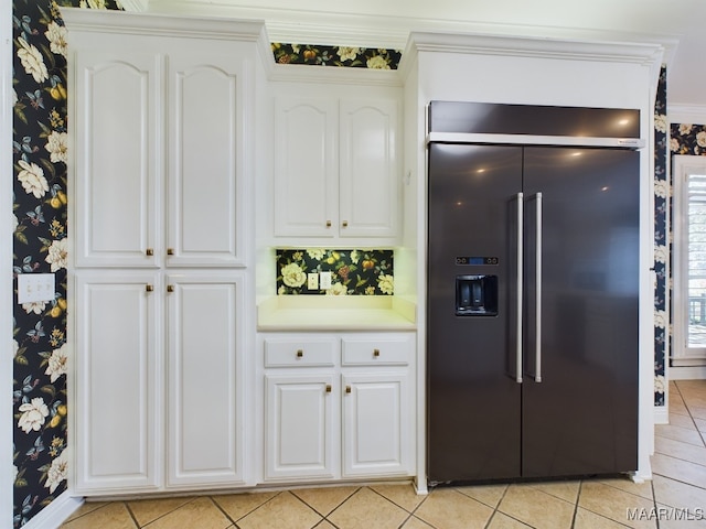 kitchen featuring white cabinets, built in fridge, light tile patterned floors, and crown molding