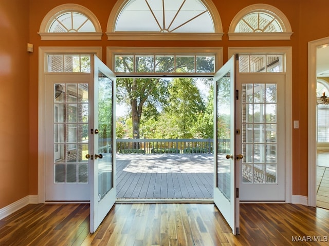 doorway featuring wood-type flooring, french doors, and a high ceiling