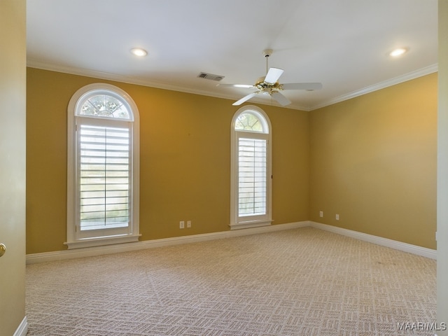 carpeted spare room featuring crown molding, a wealth of natural light, and ceiling fan