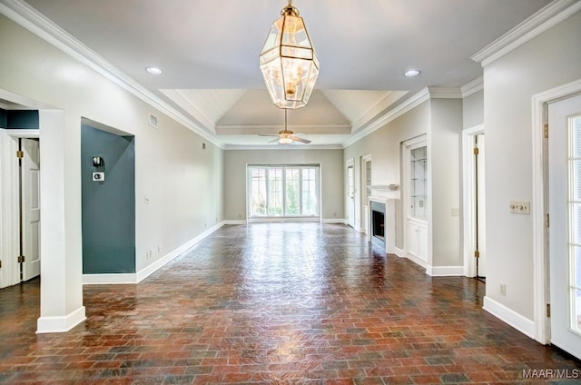 unfurnished living room featuring a tray ceiling, vaulted ceiling, crown molding, and ceiling fan