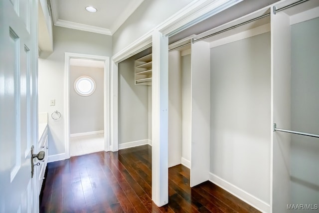 interior space with dark wood-type flooring, crown molding, and a barn door