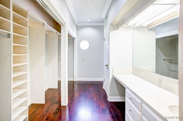 bathroom featuring hardwood / wood-style flooring, crown molding, and vanity