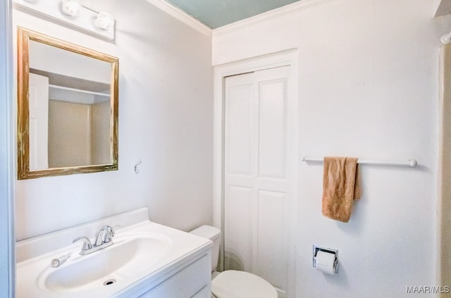 bathroom featuring vanity, ornamental molding, and toilet