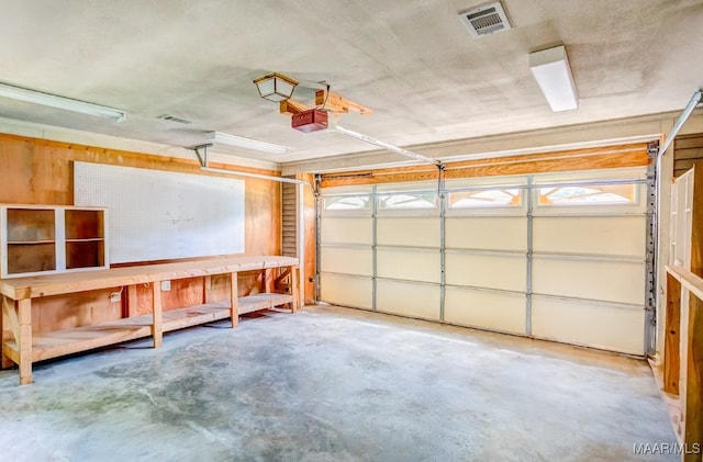 garage featuring a garage door opener and a workshop area