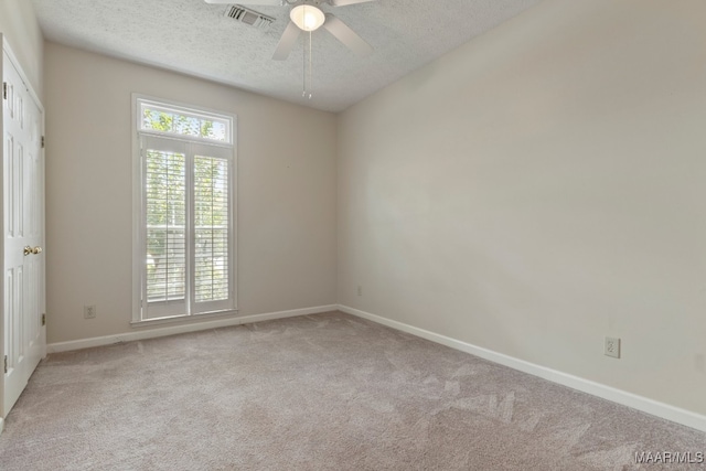 carpeted spare room with a textured ceiling and ceiling fan