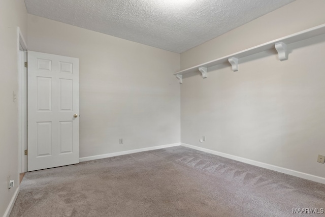 carpeted spare room featuring a textured ceiling