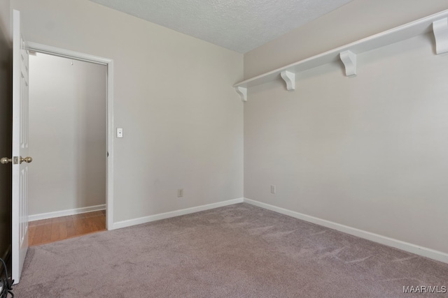 unfurnished room with a textured ceiling and carpet flooring