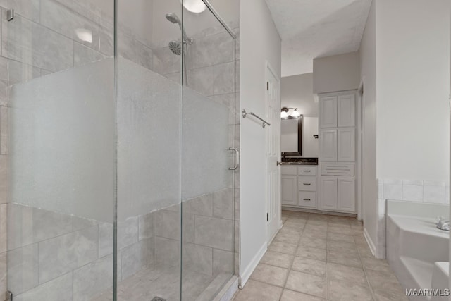 bathroom with plus walk in shower, vanity, and tile patterned floors