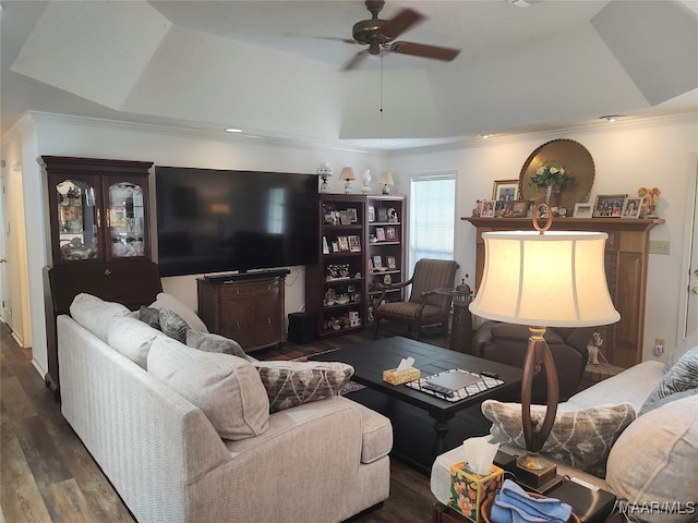 living room with ceiling fan, dark wood-type flooring, crown molding, and a tray ceiling