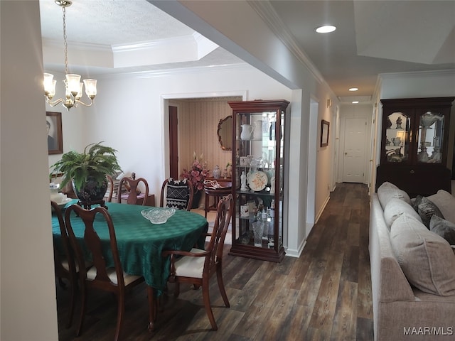 dining area featuring a notable chandelier, hardwood / wood-style flooring, a raised ceiling, and crown molding