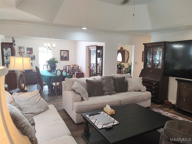 living room featuring dark hardwood / wood-style flooring, a raised ceiling, and a notable chandelier