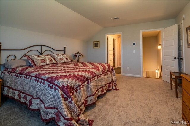 bedroom featuring light colored carpet and lofted ceiling