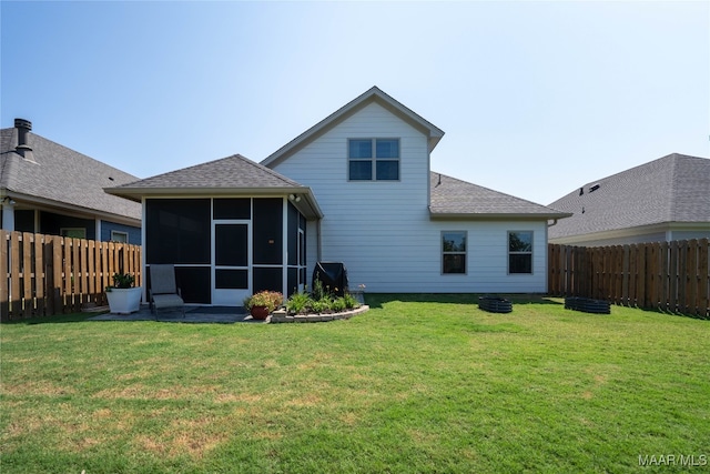 back of house featuring a sunroom and a lawn