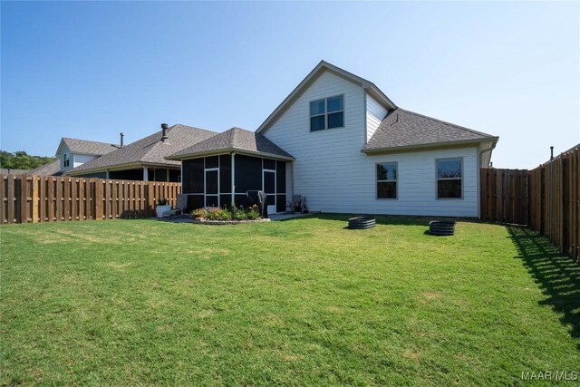 back of house featuring a lawn and a sunroom