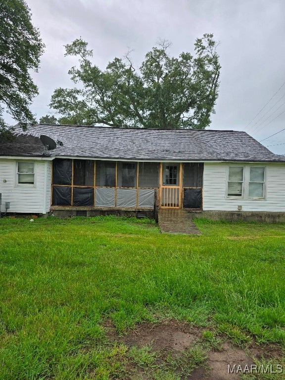 exterior space featuring a sunroom and a yard