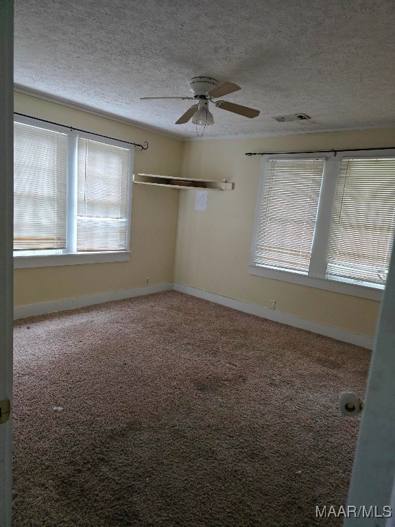 carpeted spare room with a textured ceiling and ceiling fan