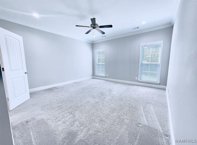 carpeted empty room featuring crown molding, a healthy amount of sunlight, and ceiling fan