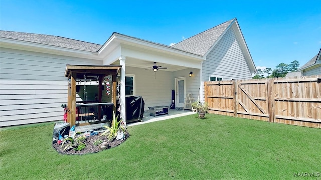 rear view of house featuring a patio, ceiling fan, and a lawn