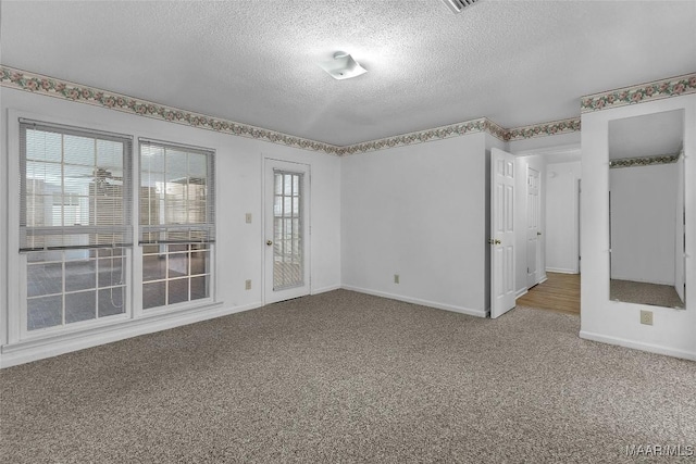 unfurnished room featuring carpet flooring and a textured ceiling