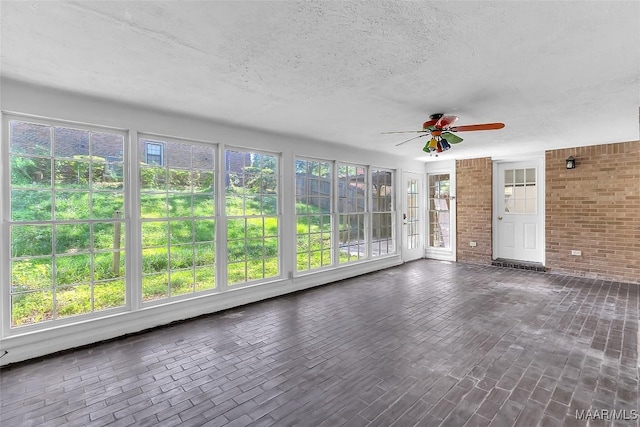 unfurnished sunroom with ceiling fan