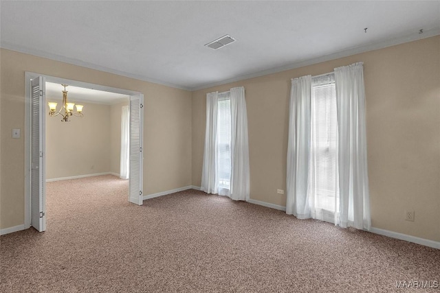 unfurnished room featuring crown molding, carpet flooring, and a chandelier