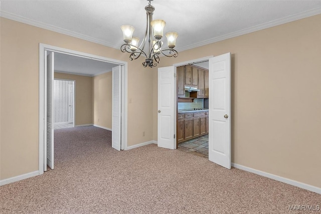 carpeted spare room with an inviting chandelier and ornamental molding