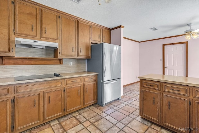 kitchen featuring stainless steel refrigerator, black electric cooktop, ornamental molding, ceiling fan, and decorative backsplash